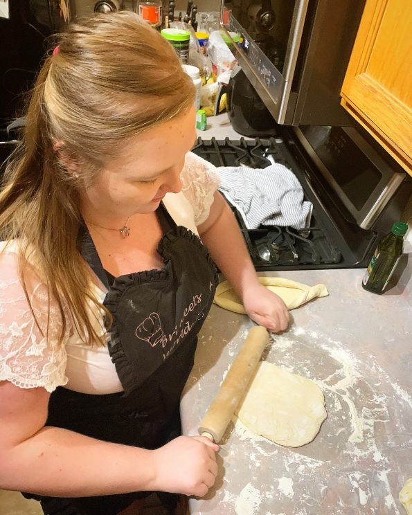 girl rolling dough making Adjaruli Khachapuri recipe